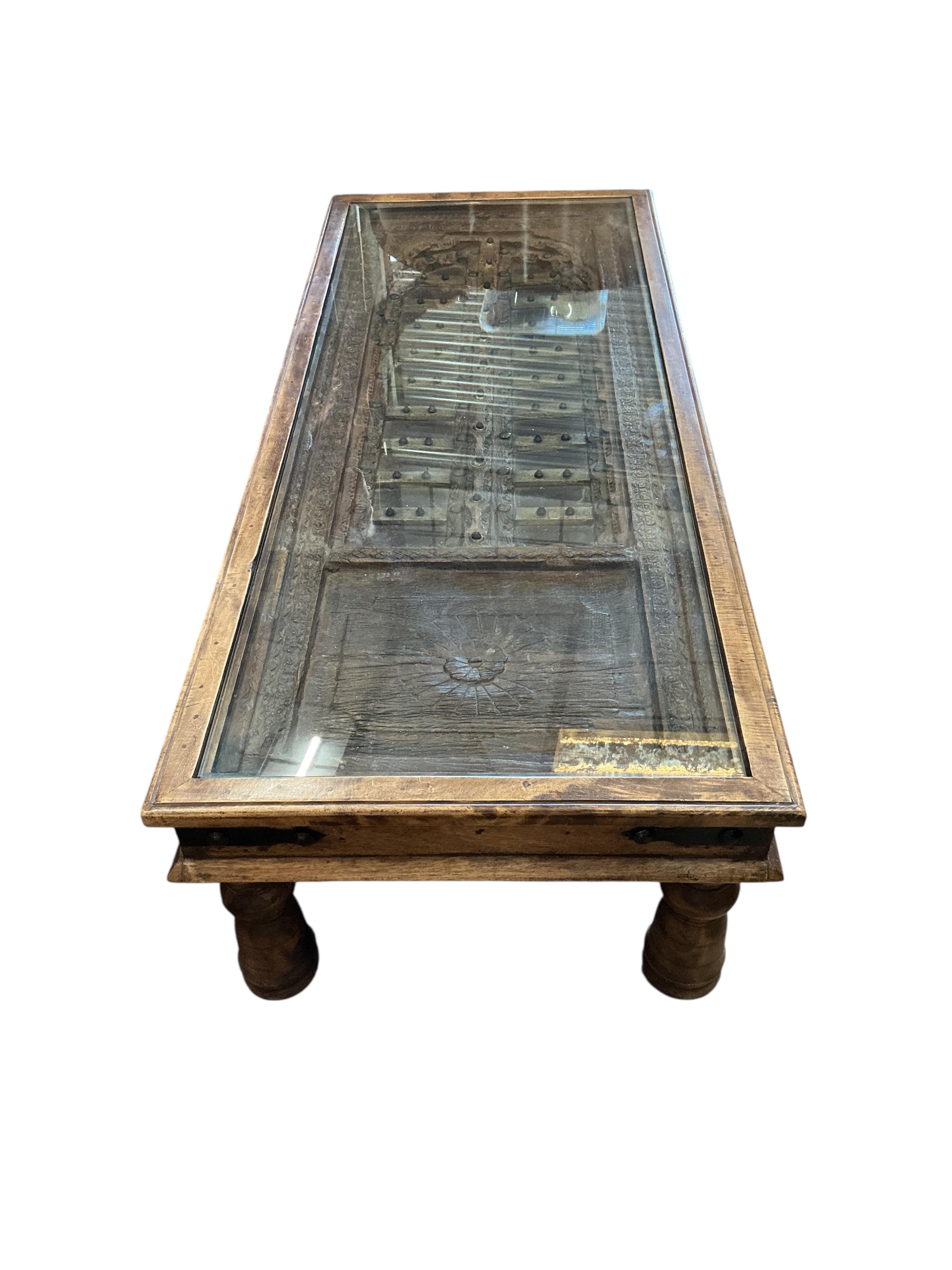 A 19th century brass mounted Indian door, now as a coffee table, width 154cm, depth 64cm, height 40cm